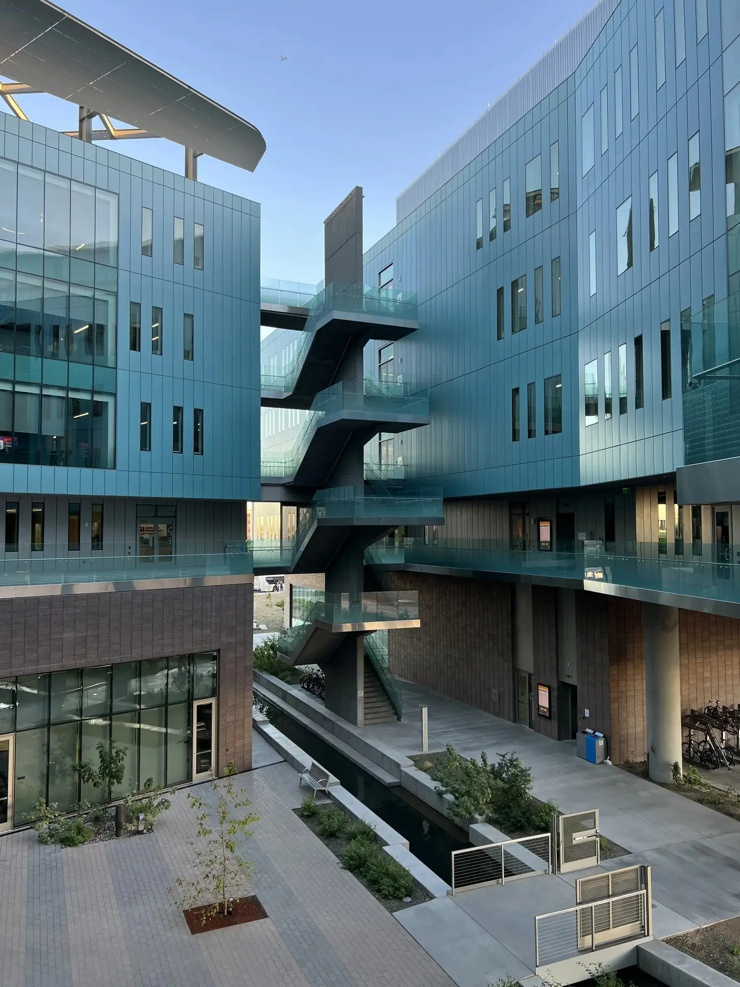 Glass-walled Rob & Melani Walton Center for Planetary Health with an outdoor plaza.